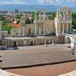 a large amphitheater with a city in the background