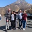 a group of people posing for a picture in front of a mountain
