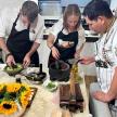 a group of three people in a kitchen preparing food