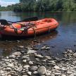 an orange raft sitting on the side of a river