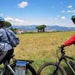 a man and a woman riding bikes in a field