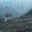 a gondola hanging from a wire over a mountain