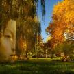 a statue of a face in a park with trees