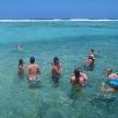 a group of people standing in the ocean