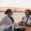 two women standing on a boat with drinks