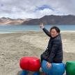 a woman is sitting on some play equipment on the beach