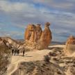 a group of people walking through a desert with rocks