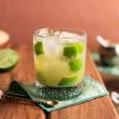 a drink with kiwi and lime on a table