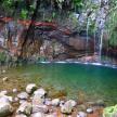 a pool of water in a cave with waterfalls