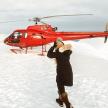a man standing in front of a red helicopter