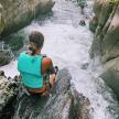 a woman sitting on a rock in a river