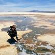 a woman and a child standing on the ground in the desert