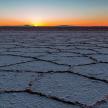 a cracked field with the sunset in the background