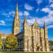 a large cathedral with three spires and a blue sky