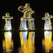 a group of three lights on the water at night