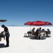 a group of people sitting at tables in the desert