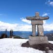 a stone cross on top of a snow covered mountain