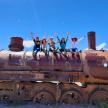 a group of people sitting on top of an old train