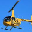 a yellow helicopter flying in the blue sky
