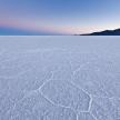 a large open field of snow with mountains in the background