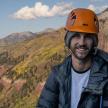 a man wearing an orange helmet on a mountain