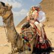 a man and a woman riding on the back of a camel