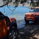 an orange truck parked next to a body of water