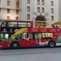 a red double decker bus parked in front of a building
