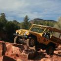 a jeep jumping over a rock in the dirt