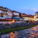 a city with a river and buildings and a mosque