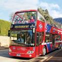 a red double decker bus driving down the street