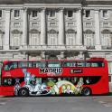 a red double decker bus parked in front of a building