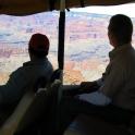 two people sitting in a bus looking out at the grand canyon