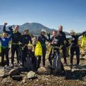 a group of people in wet suits standing on a rocky beach