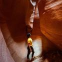 a man is standing in a slot canyon