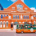 an orange double decker bus parked in front of a building
