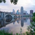 a bridge over a river with a city in the background