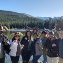 a group of people posing for a picture in front of a lake