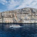 a boat in the water near a large rock formation