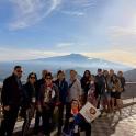a group of people posing for a picture in front of a mountain