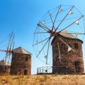 two stone windmills sitting on top of a hill