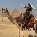 一名女子骑着骆驼在金字塔前