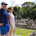 a man and a woman standing in front of a ruins