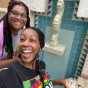 two women posing for a picture in a bathroom