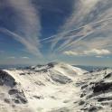 a mountain covered in snow under a cloudy sky