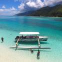 a boat on a beach with people in the water