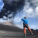 a man taking a picture of a volcano