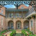 an ornate gate to a brick building with a balcony