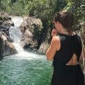 a woman talking on a cell phone in front of a waterfall