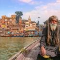 a man with a beard sitting in a boat on the water